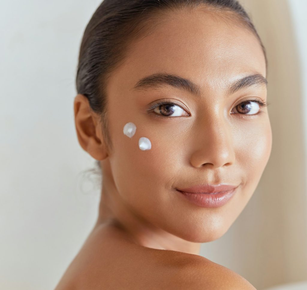 Natural Beauty. Woman Smiling With Skincare Cream On Face For Beauty Routine